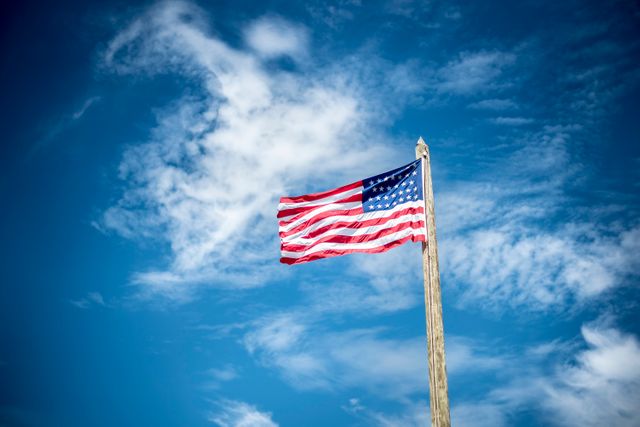 American Flag Waving Against Blue Sky with White Clouds - Download Free Stock Photos Pikwizard.com