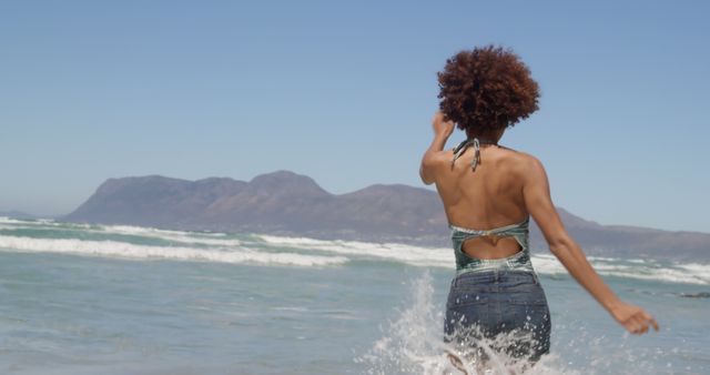 Woman Enjoying Sunny Day at Beach with Mountain View - Download Free Stock Images Pikwizard.com