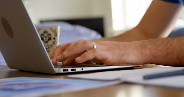 Man Typing on Laptop with Coffee and Documents - Download Free Stock Images Pikwizard.com