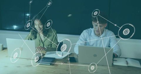Coworkers typing on laptops with glowing network overlay illustrating team connectivity
