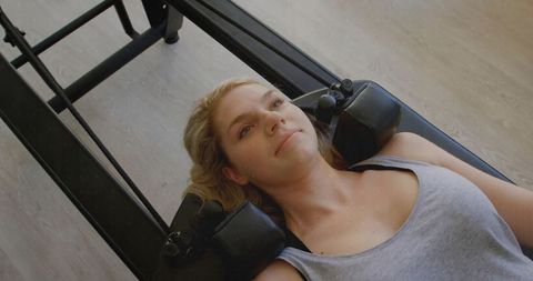 Young woman relaxing during pilates session on reformer