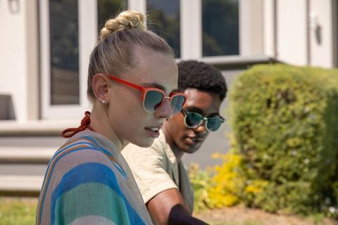 Outdoor leisure with friends wearing vibrant sunglasses on house steps