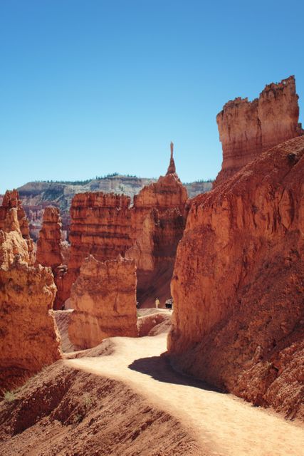 Dramatic sandstone formations and unique hoodoos in Bryce Canyon National Park with a winding hiking trail. Perfect for illustrating outdoor adventures, hiking destinations, geological wonders, and tourist attractions.