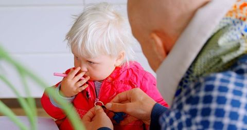 Father Helping Toddler with Jacket at Home