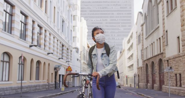 Woman Wearing Mask Walking Bicycle on City Street - Download Free Stock Images Pikwizard.com