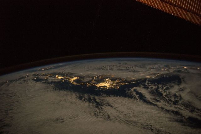 Aerial night view of Japan taken from the International Space Station in January 2016. The city's bright lights and Earth's curvature create a stunning overview. Perfect for educational purposes, space exploration articles, city planning visuals, and advertisements related to aerospace technology.