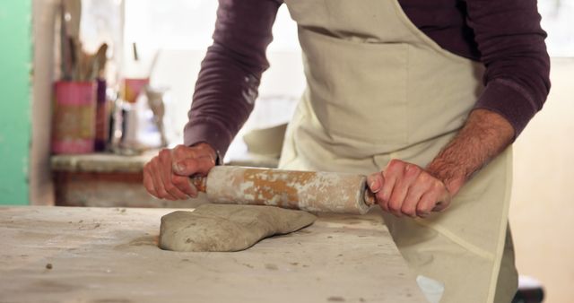 Man Rolling Out Clay on Work Surface in Pottery Studio - Download Free Stock Images Pikwizard.com