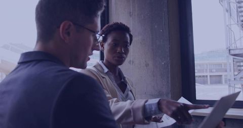 Office Workers Collaborating on Laptop Project near Window View
