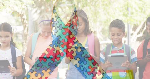 Children using tablets with autism awareness ribbon overlay
