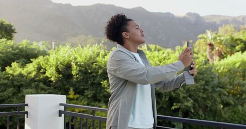 Man Relaxing on Balcony Amidst Scenic Mountain Landscape