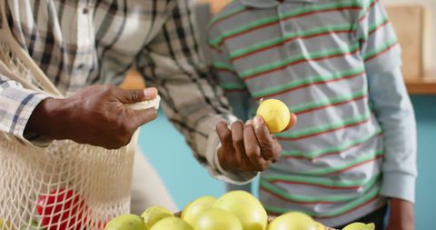 Grandfather and Grandson Choosing Vegetables at Greengrocers