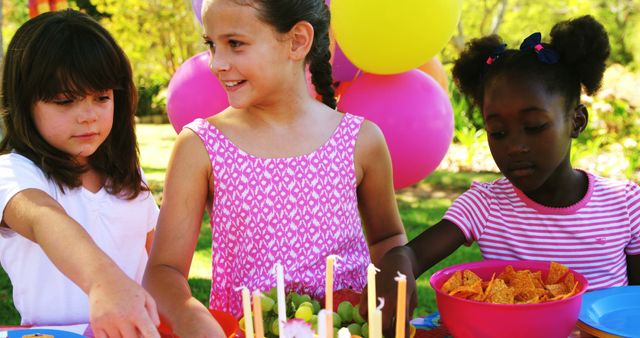 Children celebrating outdoor birthday party with cake and snacks - Download Free Stock Images Pikwizard.com