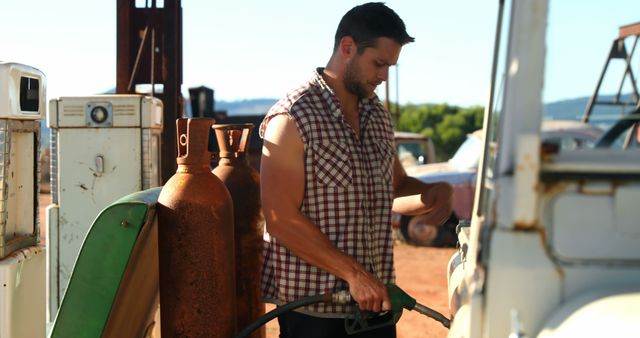 Caucasian man refueling a vehicle at an outdoor station. He's focused on the task, ensuring his vehicle is ready for the road ahead.