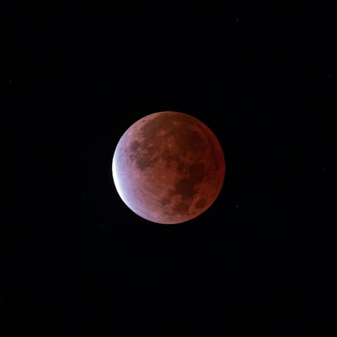 Dramatic Blood Moon and Lunar Eclipse Against Starry Sky