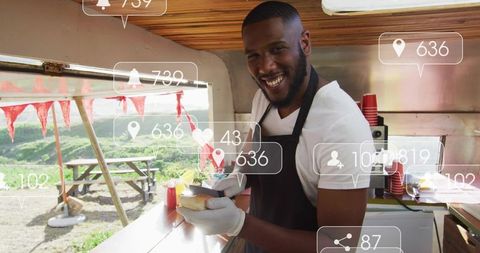 Smiling street food vendor serving sandwich at sunny food truck with social media icons