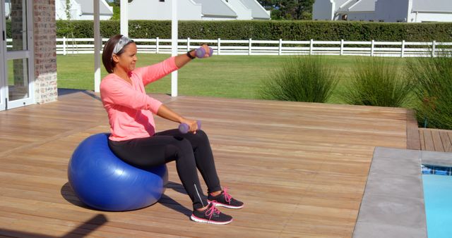 Woman Exercising with Dumbbells on Stability Ball Near Pool - Download Free Stock Images Pikwizard.com