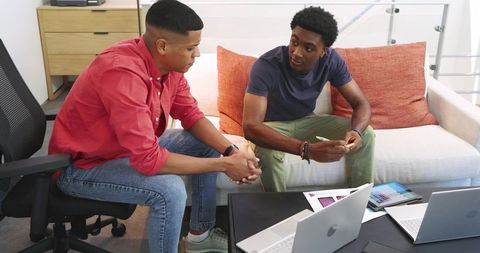Creative coworkers discussing design mockups in modern office lounge