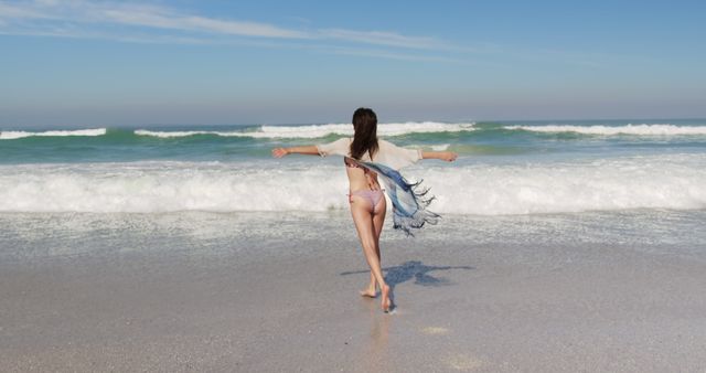 Woman Enjoying Walk on Sandy Beach With Waves in Background, Blue Sky - Download Free Stock Images Pikwizard.com