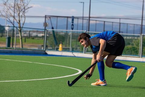 Teenage athlete training on field hockey turf outdoors