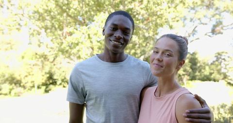 Smiling Diverse Couple Embracing in Sunlit Park