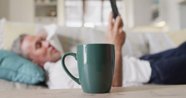 Relaxed Man Lounging on Sofa with Mug in Foreground - Download Free Stock Images Pikwizard.com