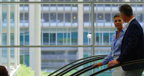 Business Professionals Conversing on Escalator in Modern Office
