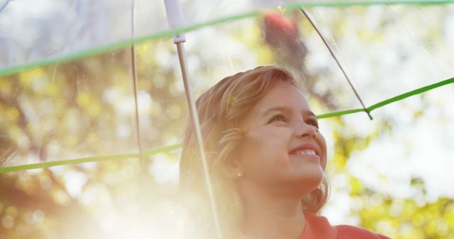 Smiling Girl Under Clear Umbrella in Sunlit Park - Download Free Stock Images Pikwizard.com