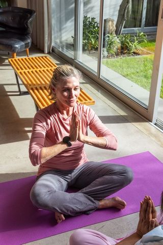 Senior Woman Practicing Yoga Indoors with Smartwatch