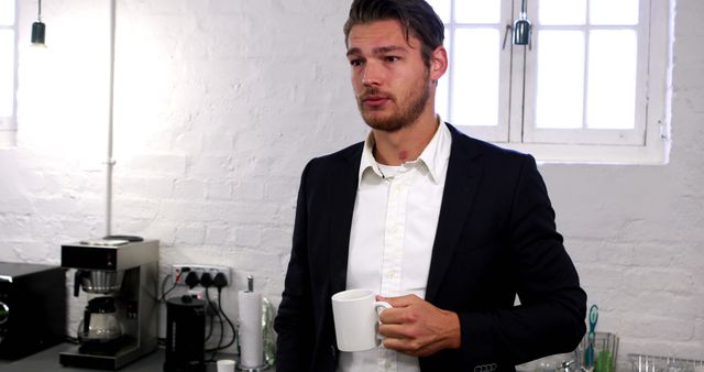 Handsome businessman having a coffee break in the office