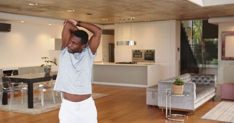 Young Man Stretching in Modern Minimalist Home Interior
