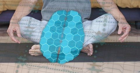 Asian man meditating cross-legged on mat with blue digital brain overlay for mindfulness