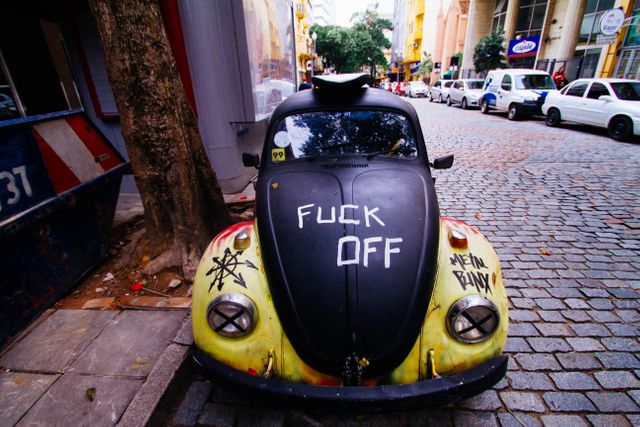 Graffitied Vintage Car Parked on Cobblestone Street in Urban Area - Download Free Stock Images Pikwizard.com