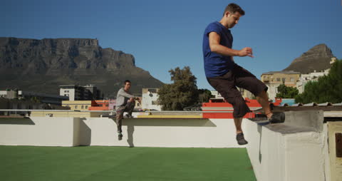 Man Practicing Parkour on Urban Rooftop on Sunny Day