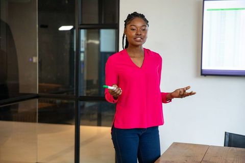 African American Woman Presenting Data in Conference Room