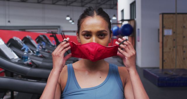 Fit caucasian woman wearing face mask in the gym. social distancing quarantine lockdown during coronavirus pandemic
