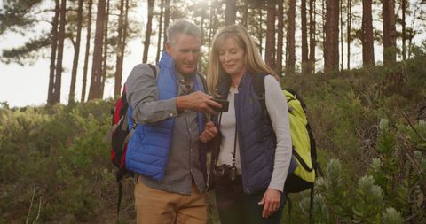 Happy Senior Couple Hiking and Browsing Smartphone in Forest - Download Free Stock Images Pikwizard.com