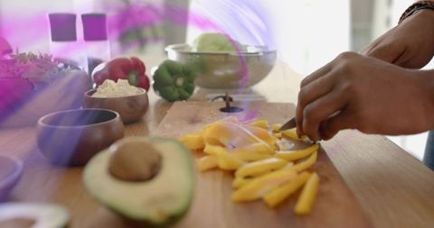 Hands slicing yellow bell pepper in minimalist kitchen