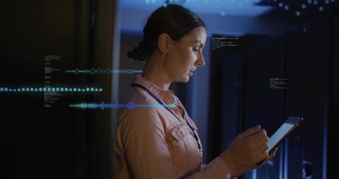 Female IT Technician Monitoring Data Center Servers with Tablet and Digital Diagnostics