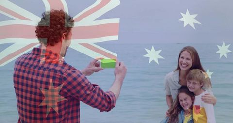Father capturing family portrait on beach with australian flag overlay for holiday travel