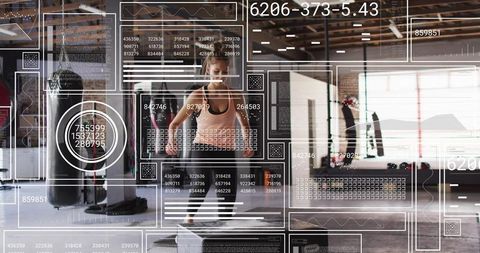 Female athlete performing box jump in industrial gym with augmented reality fitness hud