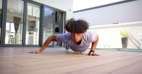 Man Doing One-Arm Push-Ups on Wooden Deck Outdoors
