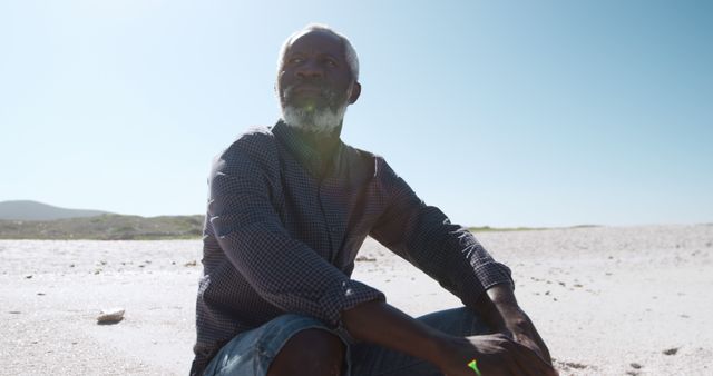 Senior Man Reflecting at Tranquil Beach on Sunny Day - Download Free Stock Images Pikwizard.com