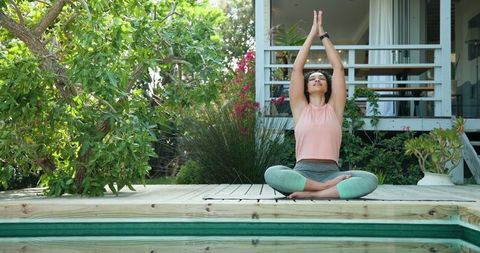 Outdoor Yoga Meditation beside Pool with African American Woman