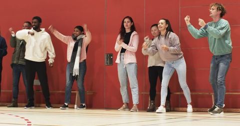 Group Performing Energy-Building Exercises in Sports Venue