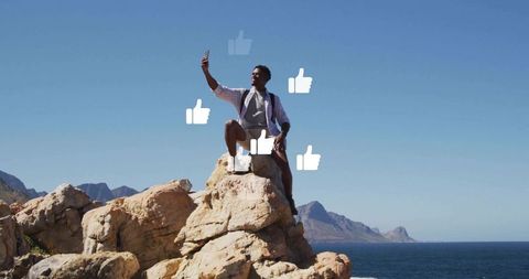 Hiker Taking Selfie on Cliff With Thumbs-Up Icons Overlooking Ocean