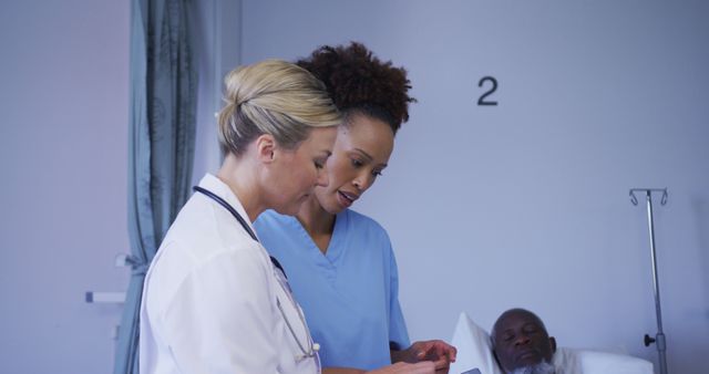 Doctors and nurses are consulting patient records in a hospital room. They are discussing patient care options and treatment plans. Ideal for use in medical websites, healthcare articles, hospital brochures, and healthcare worker recruitment campaigns.