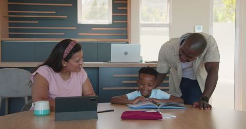 Happy diverse family bonding over educational activities at home