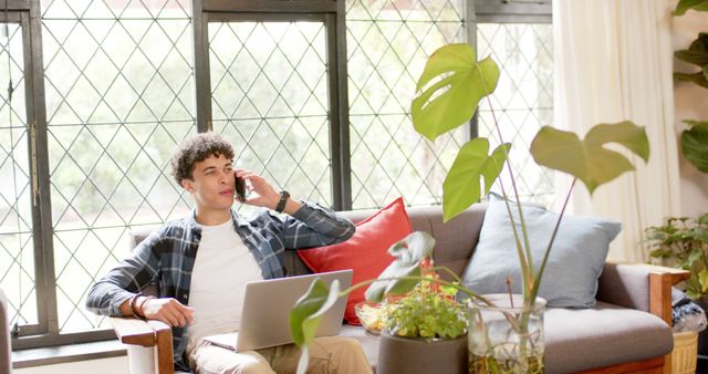 Young Man Sitting on Couch in Modern Living Room Taking Phone Call - Download Free Stock Images Pikwizard.com