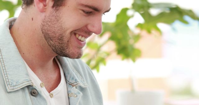 Smiling Man in Light Denim Jacket Working Online with Greenery Background - Download Free Stock Images Pikwizard.com