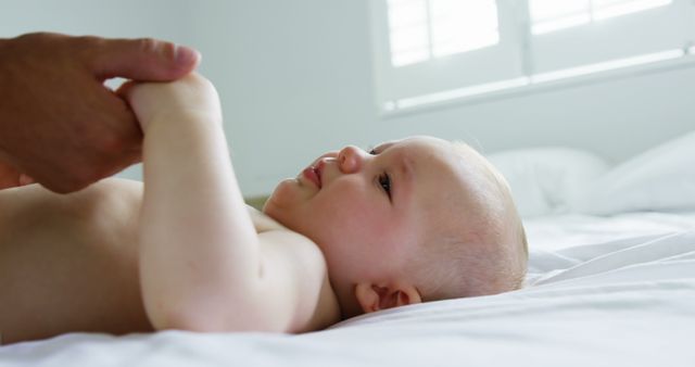 Smiling Baby Holding Parent's Hands in Bright Bedroom - Download Free Stock Images Pikwizard.com